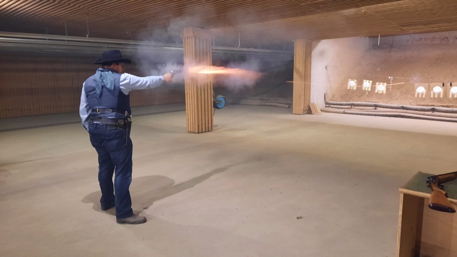 Schütze beim Cowboy Action Shooting gibt einen Revolverschuss auf dem Schießstand ab
