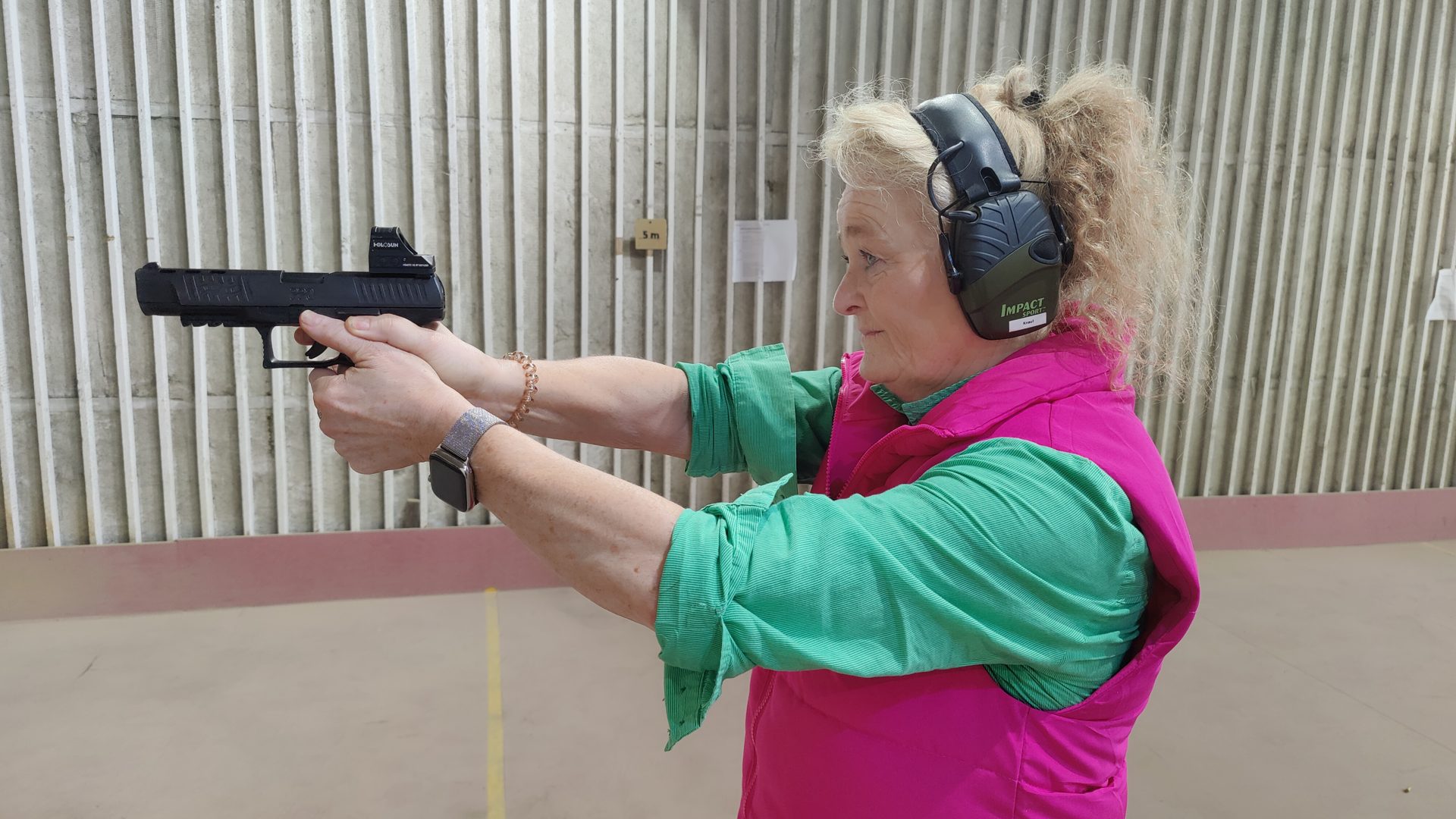 Sportschützin mit Gehörschutz beim Training mit der Kurzwaffe